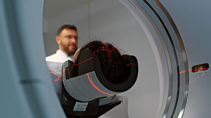 Doctor radiologist observing patient undergoing MRI, CT or PET scan